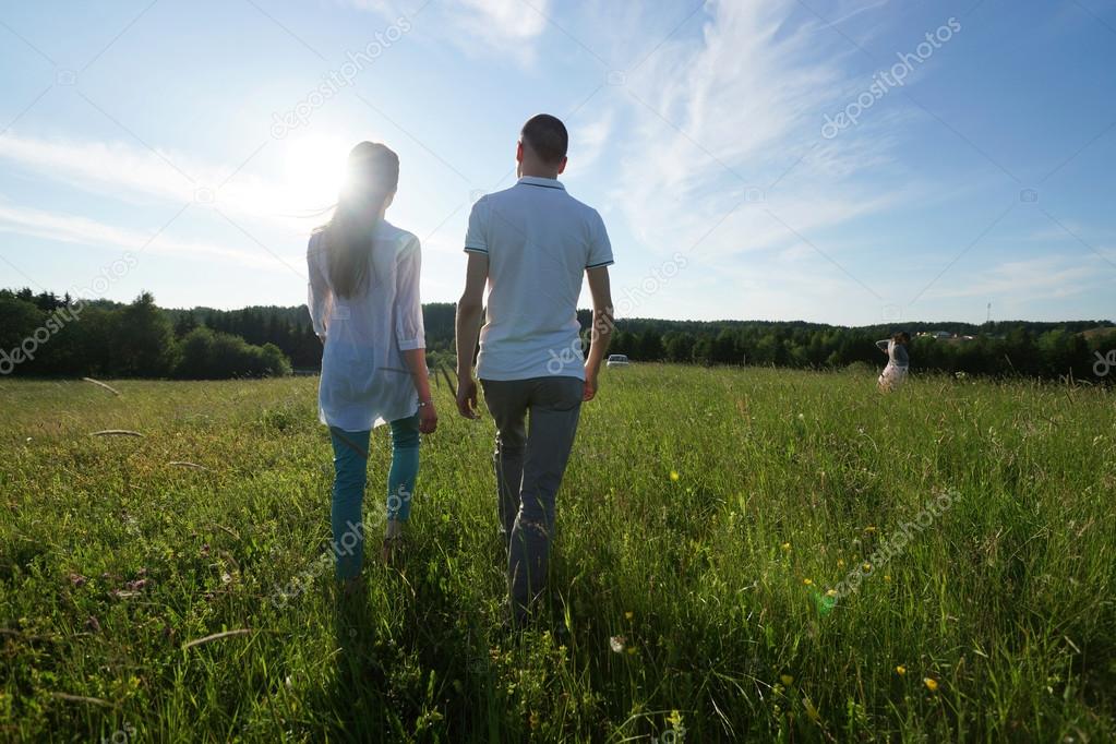 couple walking through field
