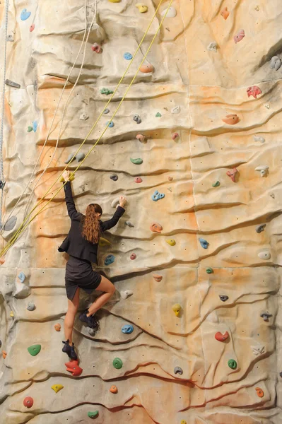 Business woman on rock wall — Stock Photo, Image