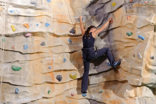 Young woman on rock wall — Stock Photo, Image