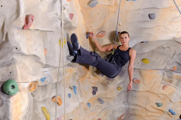 Woman on rock wall in sport centre — Stock Photo, Image