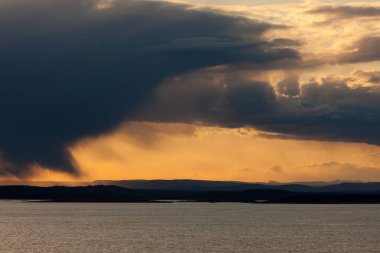 Gün batımında denizin üzerindeki bulutlarla dramatik manzara