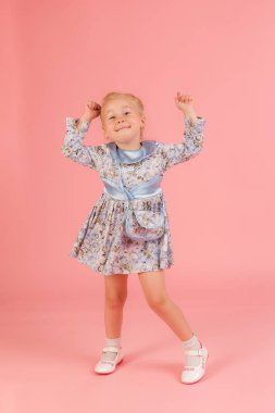 Dans eden küçük bir kızın stüdyo portresi.