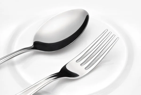 Flatware. Spoon and fork on a plate — Stockfoto