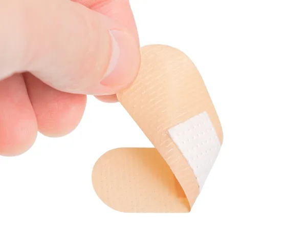 Självhäftande bandage och hand på vit bakgrund — Stockfoto