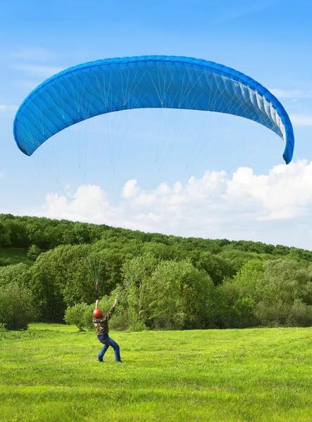 Paraglider. man met parachute worstelen met de wind. — Stockfoto