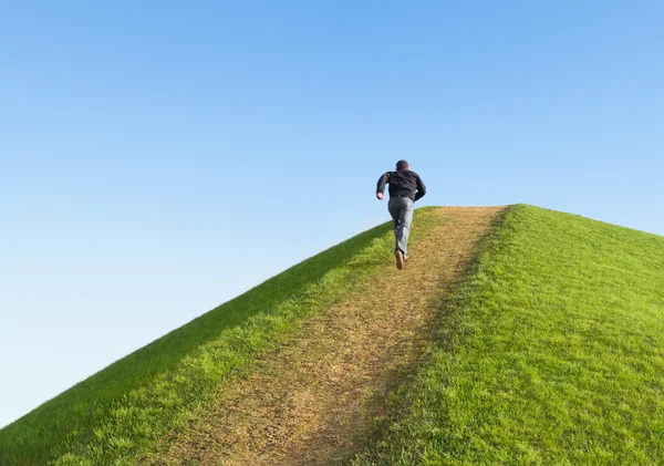 Väg upp i backen mot himlen. mannen sprang till toppen. symbol — Stockfoto