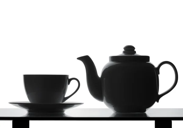 Teekanne und Tasse auf dem Tisch vorhanden. Silhouette — Stockfoto