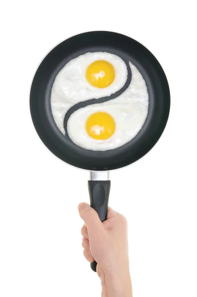 Stekta ägg i form av yin och yang på pannan. panorera i handen på wh — Stockfoto