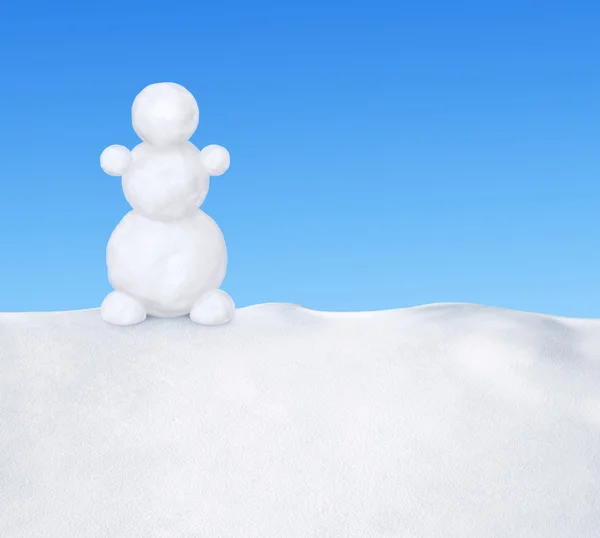 Muñeco de nieve en la nieve contra el cielo azul — Foto de Stock