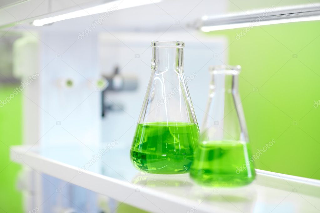 flasks with green liquid on the background of the chemical labor