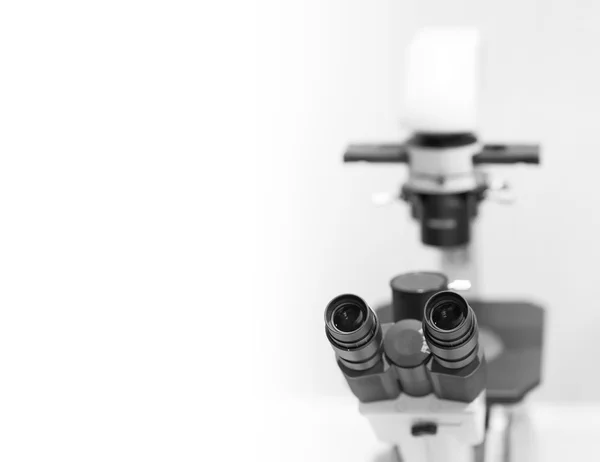Microscópio em laboratório, fundo com um campo para texto — Fotografia de Stock