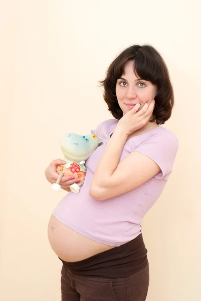 Menina de gravidez jovem bonita com brinquedo — Fotografia de Stock