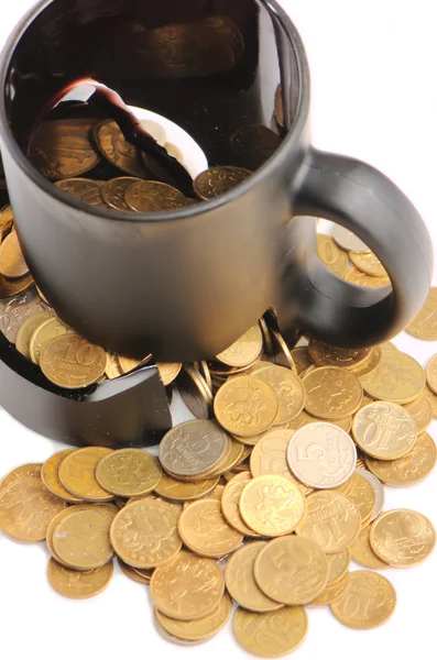 Taza rota y monedas sobre una mesa, fondo blanco — Foto de Stock