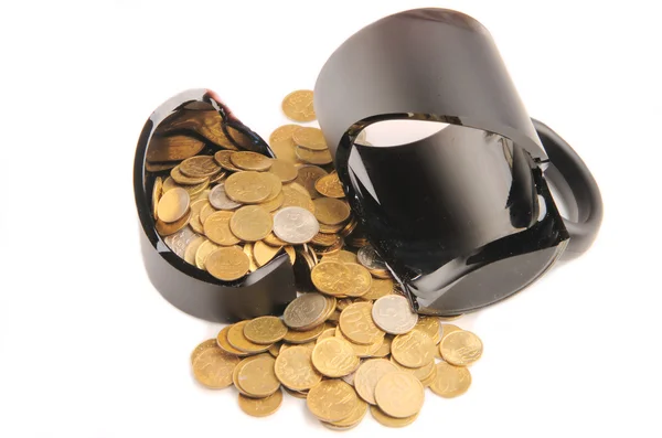 Broken mug and coins on a table, white background — Stock Photo, Image