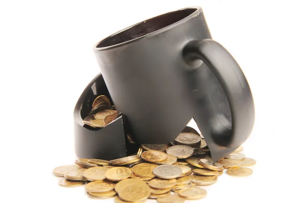 Broken mug and coins on a table, white background — Stock Photo, Image