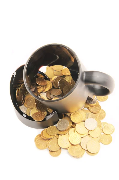 Taza rota y monedas sobre una mesa, fondo blanco — Foto de Stock