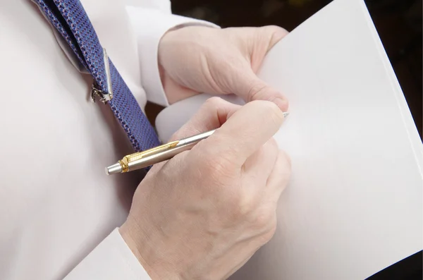 Empresario sosteniendo hoja de papel y pluma — Foto de Stock