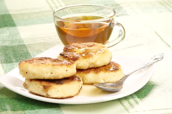 Heerlijke huisgemaakte kaas pannenkoeken met honing — Stockfoto