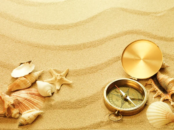 Conchas do mar e bússola velha com areia — Fotografia de Stock