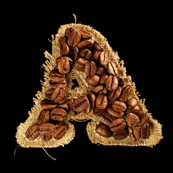 Alfabeto de grãos de café na textura do tecido isolado em preto — Fotografia de Stock