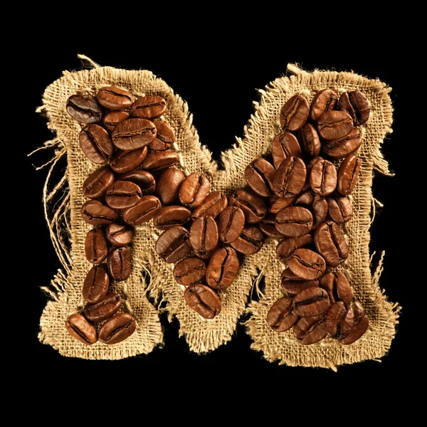 Alphabet from coffee beans on fabric texture isolated on black — Stock Photo, Image