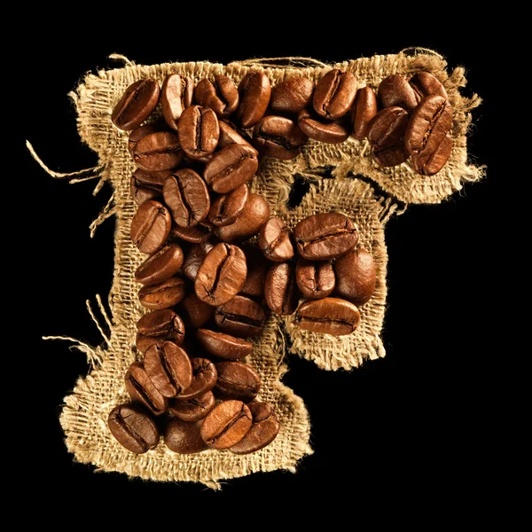 Alfabet z ziaren kawy na tekstura tkanina na czarnym tle — Zdjęcie stockowe