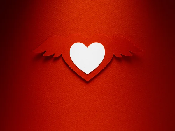 Valentine heart with angel wings made of paper on red paper background — Stock Photo, Image