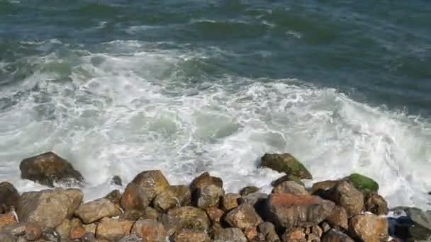 Камень с большими камнями в море и волны с пеной — стоковое видео