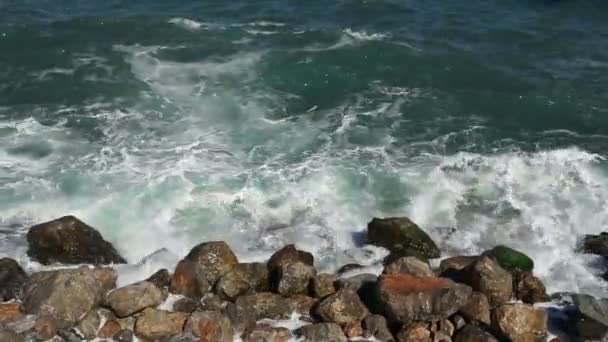 Камень с большими камнями в море и волны с пеной — стоковое видео