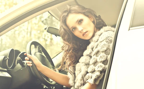 Mooie jonge vrouw in luxeauto — Stockfoto