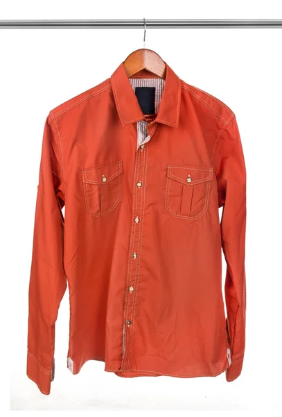 Оранжевая рубашка на вешалке — стоковое фото
