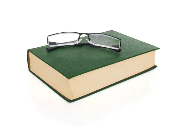 Óculos no livro — Fotografia de Stock