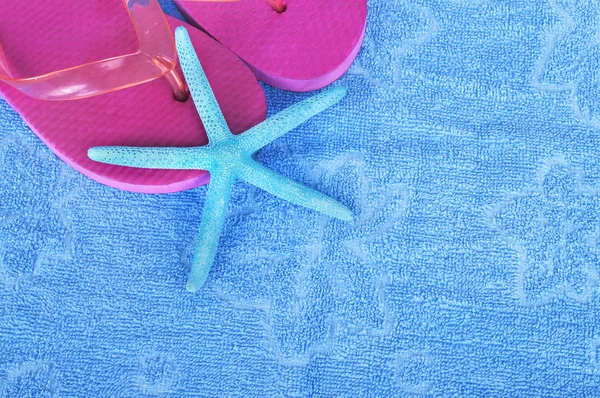 Beach items with flip flops and starfish on towel background — Stock Photo, Image
