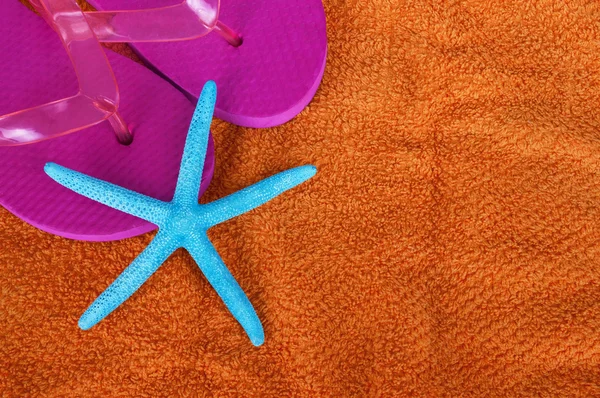 Beach items with flip flops and starfish on towel background — Stock Photo, Image