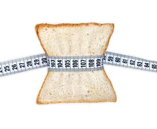 Piece of bread grasped by measuring tape — Stock Photo, Image