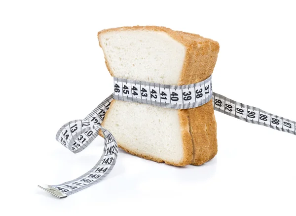 Piece of bread grasped by measuring tape — Stock Photo, Image