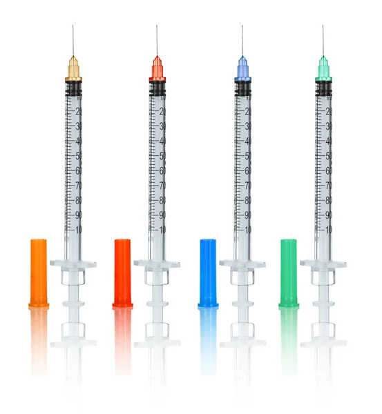 Collection needles and syringes with caps on an isolated white b — Stock Photo, Image