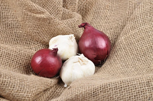 Onions and garlic on jute — Stock Photo, Image