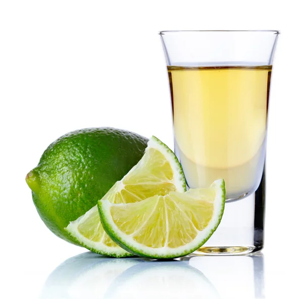 Guld tequila shot med lime isolerad på vit Stockbild