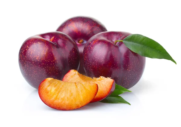 Ripe purple plum fruits with green leaves isolated — Stock Photo, Image