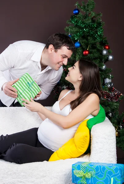 Gelukkige zwangere paar in de buurt van de kerstboom — Stockfoto