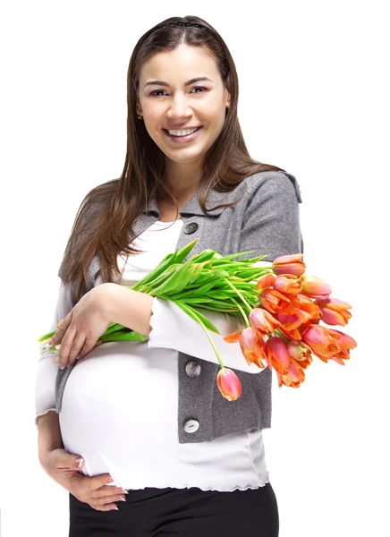 Szczęśliwa ciężarna kobieta z tulipanami — Zdjęcie stockowe