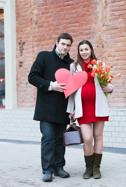 Счастливая молодая беременная женщина с мужем на улице — стоковое фото