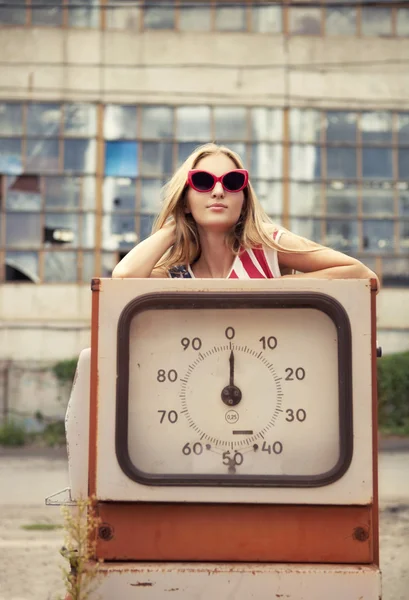 Blondes Mädchen an beschädigter Tankstelle — Stockfoto