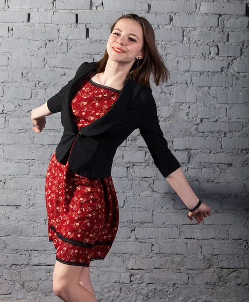 Jonge schattige brunette tiener meisje in een rode jurk — Stockfoto