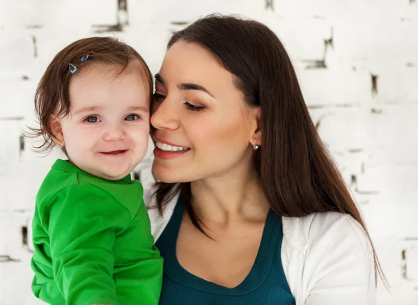 Glücklich lächelnde Mutter mit hübschem kleinen Mädchen — Stockfoto