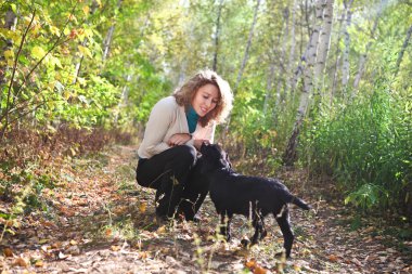 Young woman with black labrador retriever puppy clipart