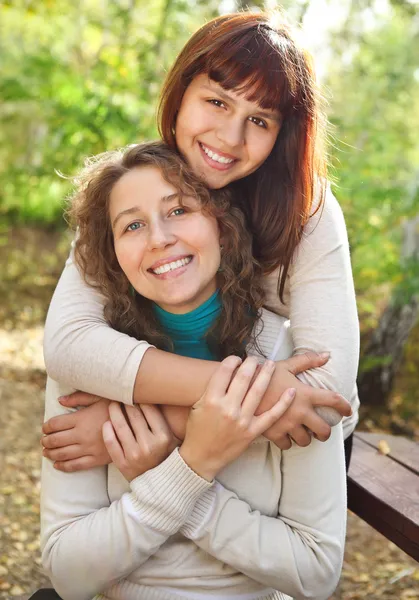 Young smiling woman with her teen daughter — Stock Photo, Image