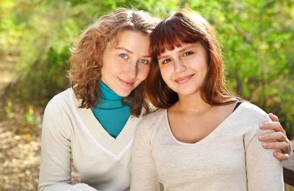 Joven mujer sonriente con su hija adolescente —  Fotos de Stock