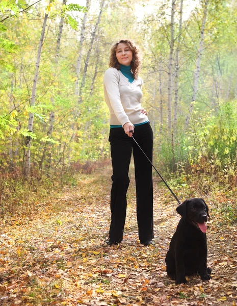 Mladá žena s černým Labradorský retrívr štěně — Stock fotografie